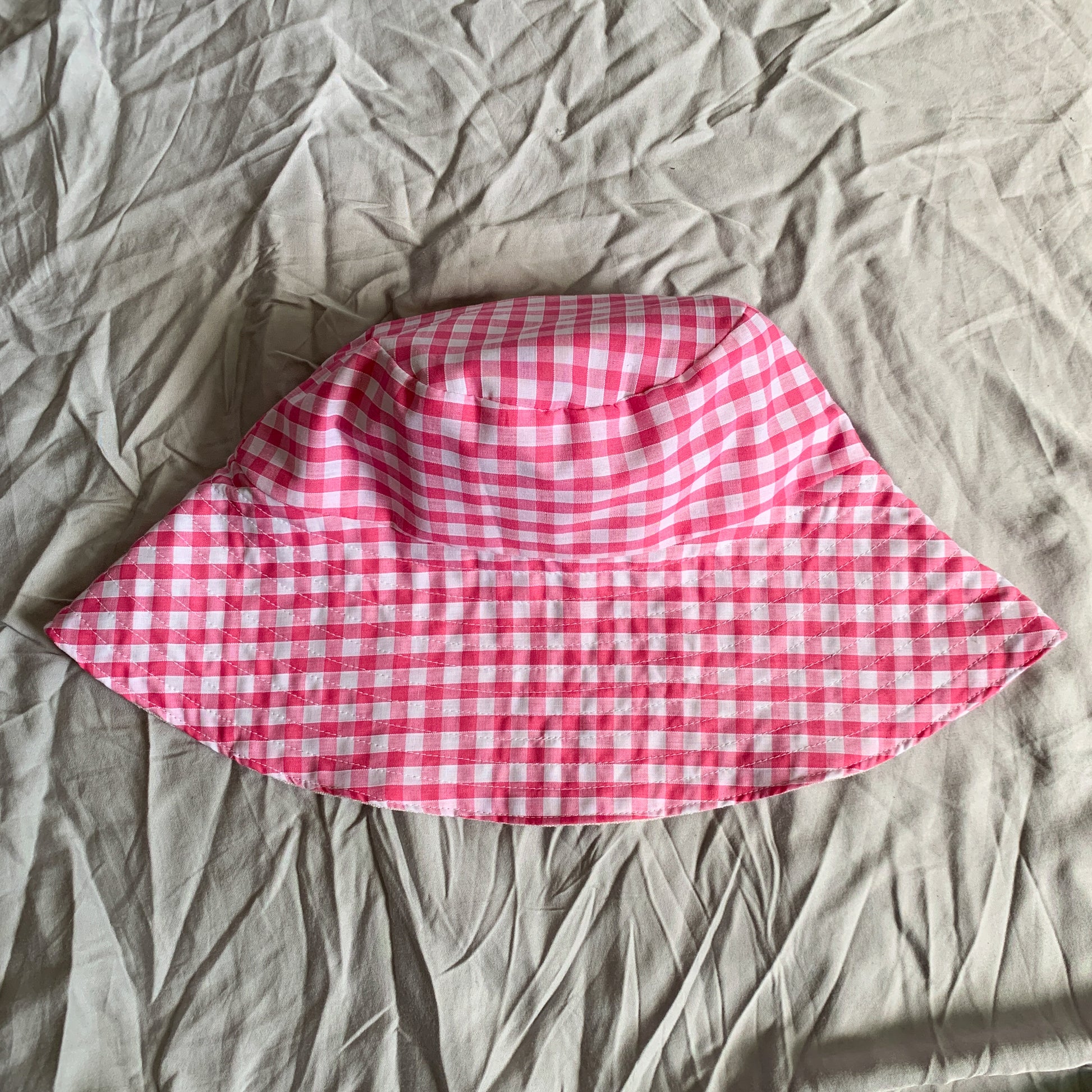 A bright pink gingham bucket sun hat