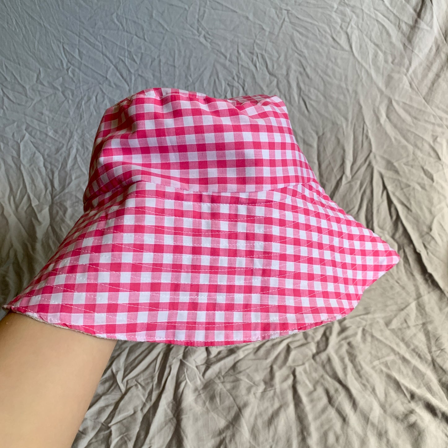 A bright pink gingham bucket sun hat