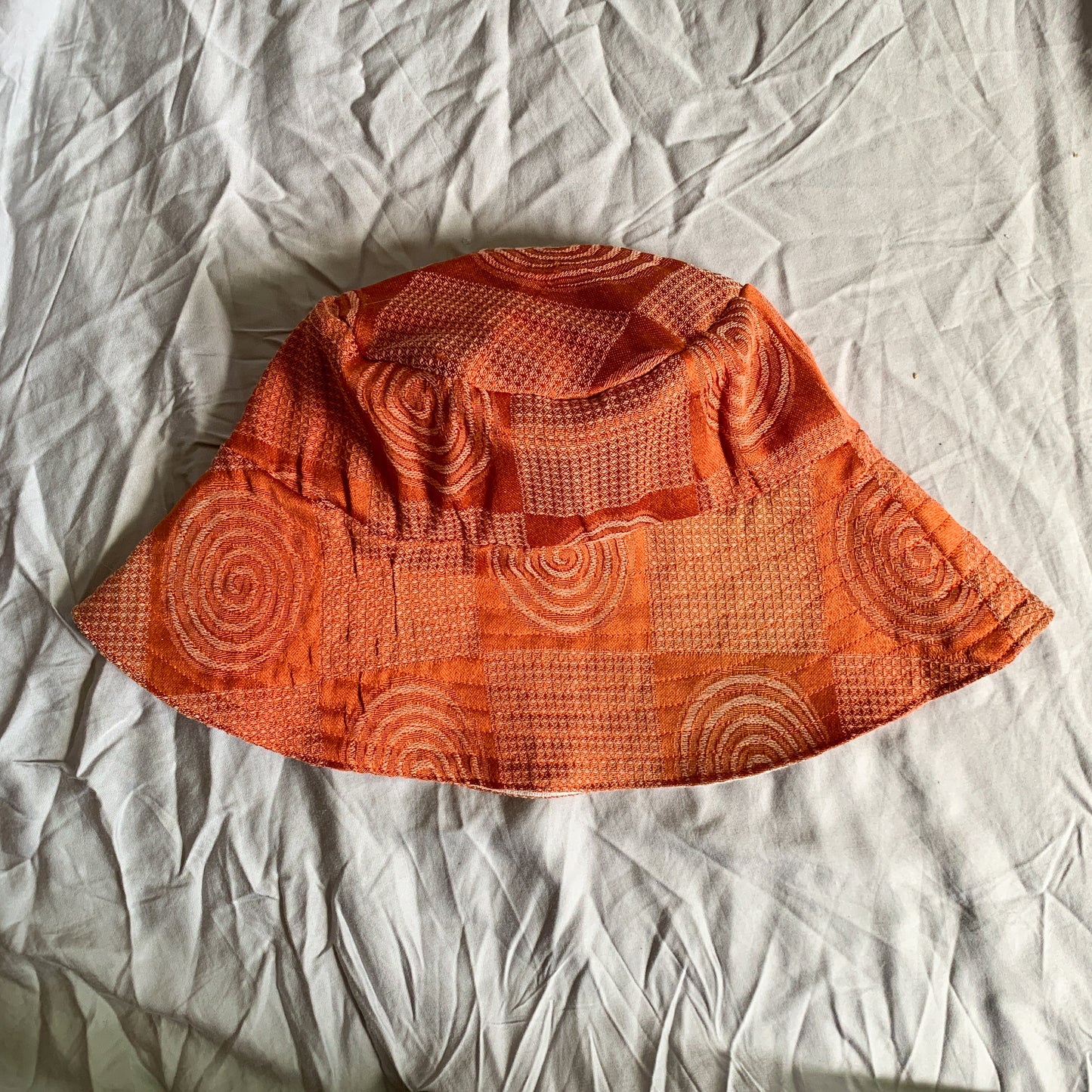 A rust orange coloured swirly patterned bucket sun hat