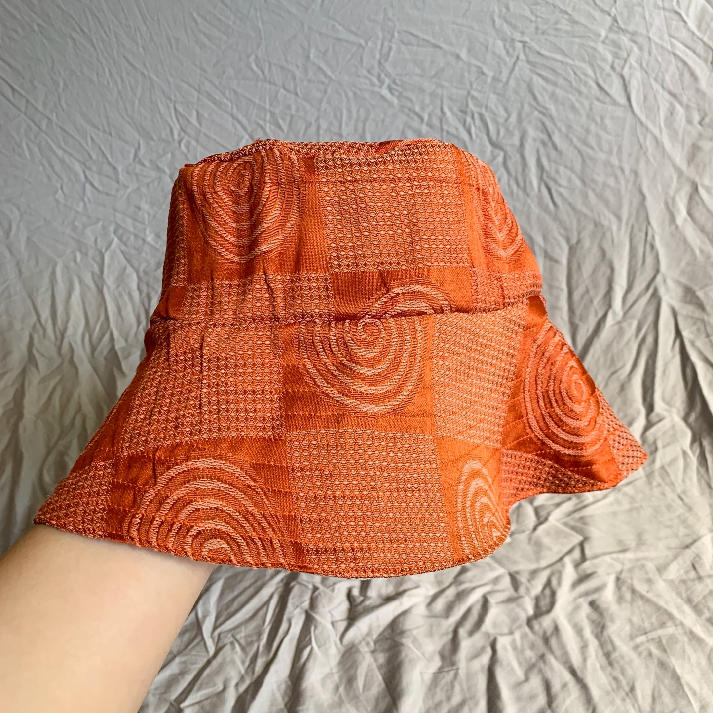 A rust orange coloured swirly patterned bucket sun hat