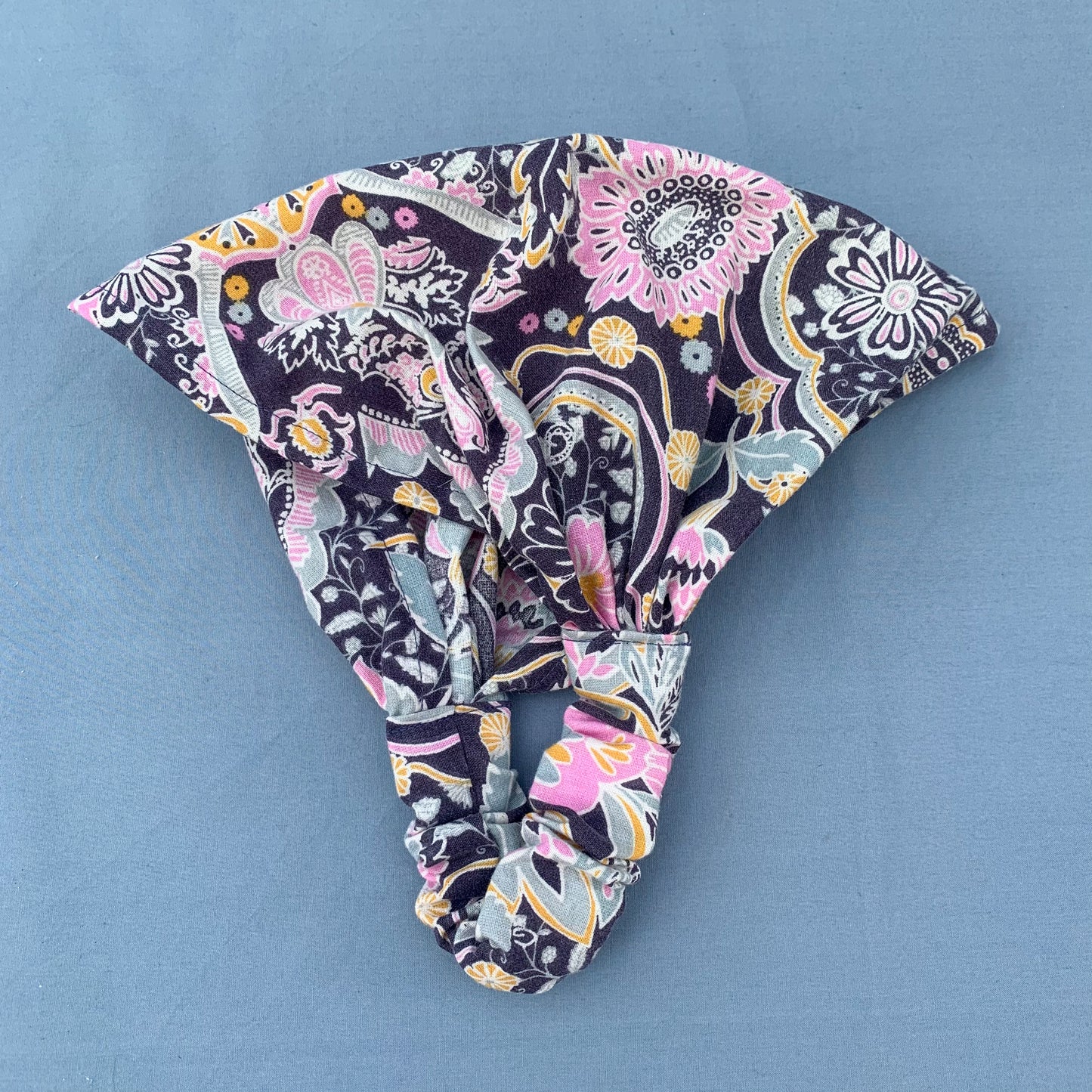 a folded purple floral bandana on a blue background