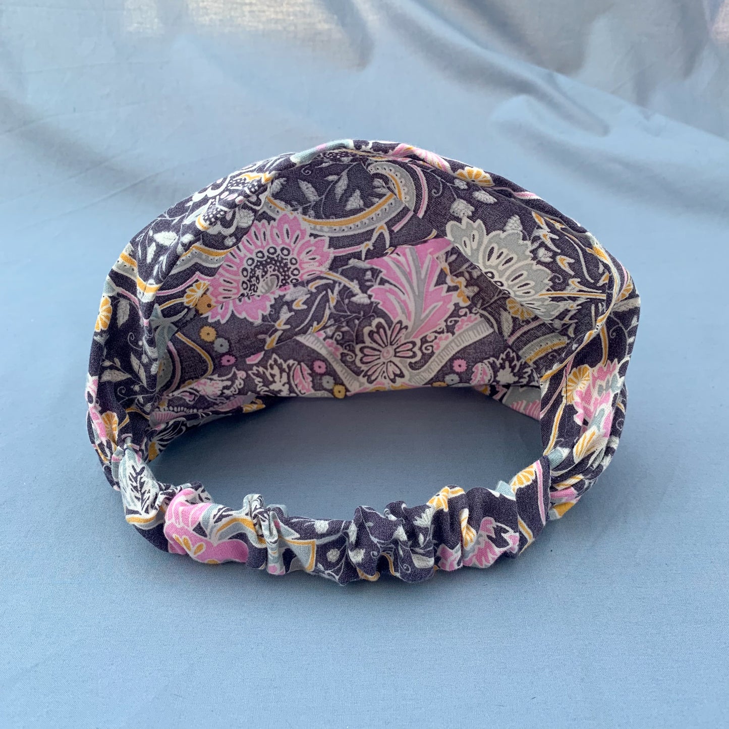 the inside of a purple floral bandana against a blue background