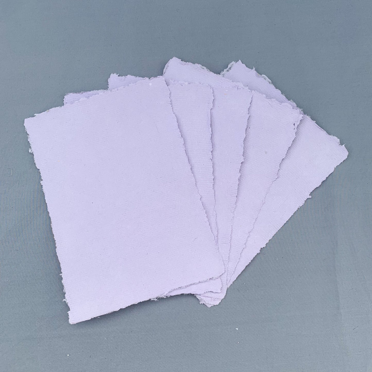 five fanned out sheets of purple paper across a blue background