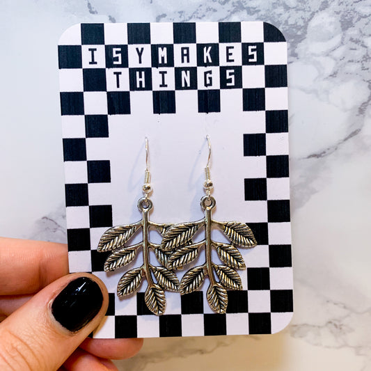 Silver leaf dangle earrings on a black and white checkered backing card with the title isymakesthings