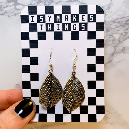 Silver leaf dangle earrings on a black and white checkered backing card with the title isymakesthings