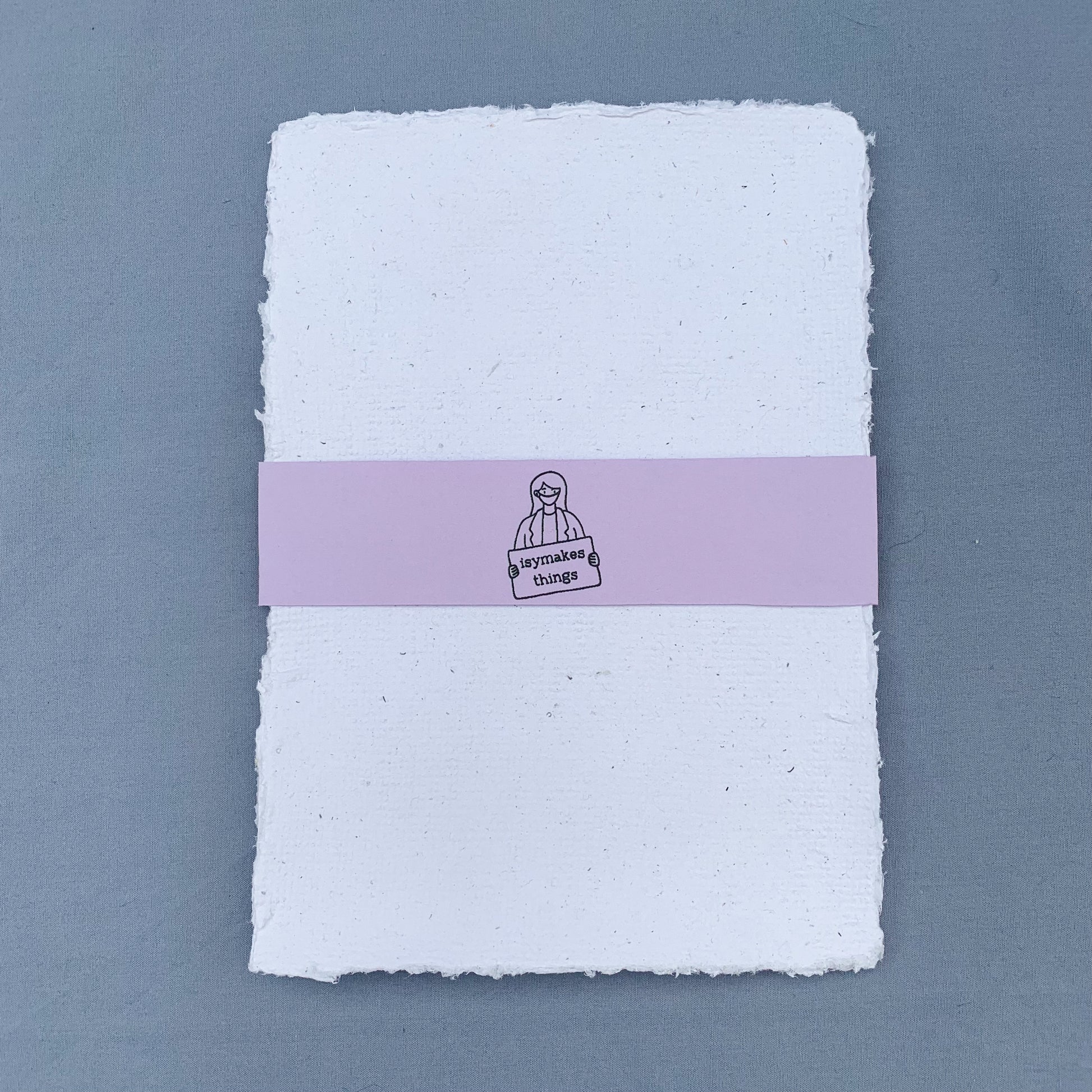 a stack of white sheets of paper with a purple coloured isymakesthings logo sleeve around them against a blue background